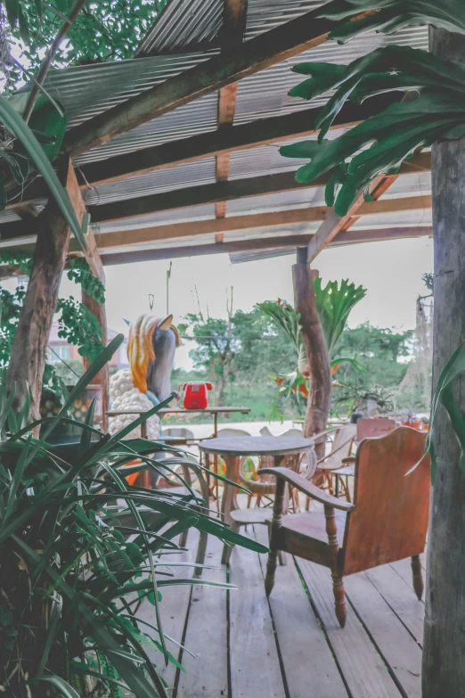 a large wooden patio with chairs and trees