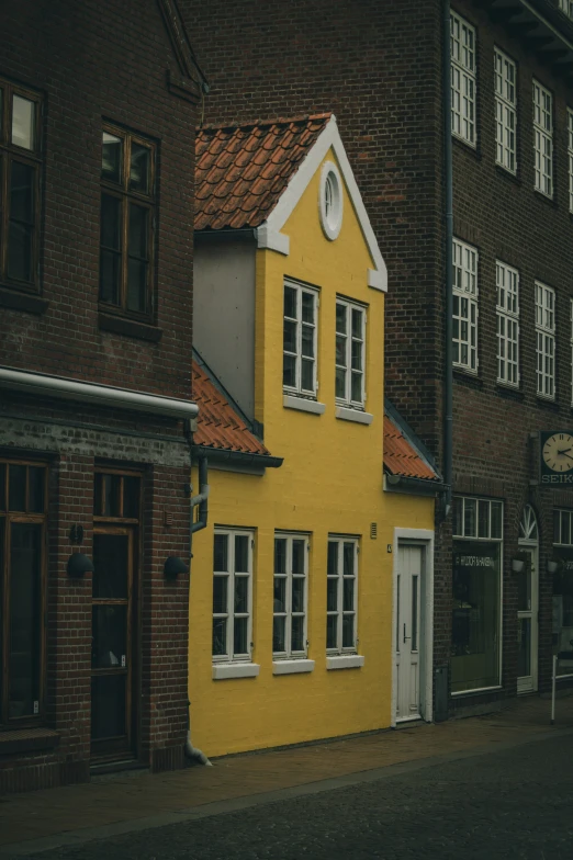 a building with windows and shutters next to a brick building