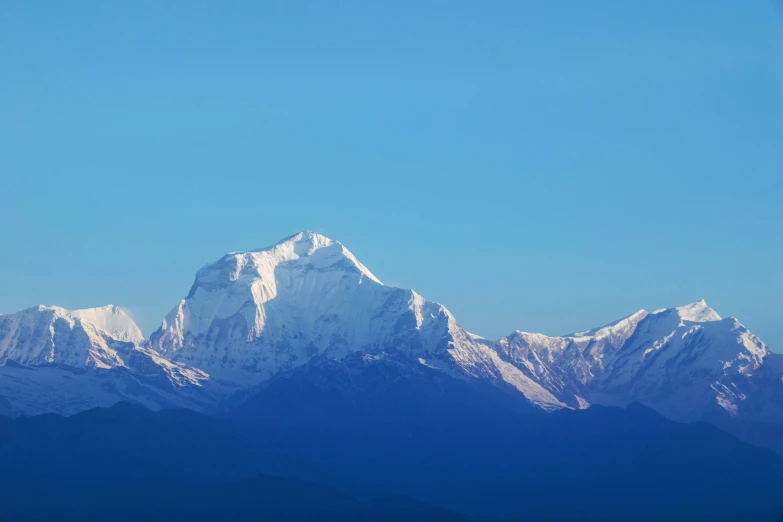 the top of the snowy mountains is illuminated by the sun