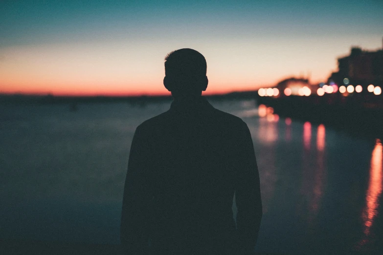 a man standing in front of a body of water