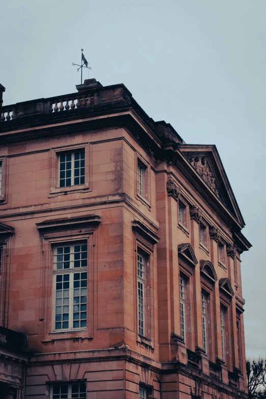 the corner of an old building with many windows and a roof