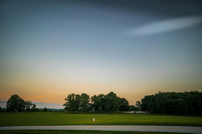 a person standing in the distance while flying a kite