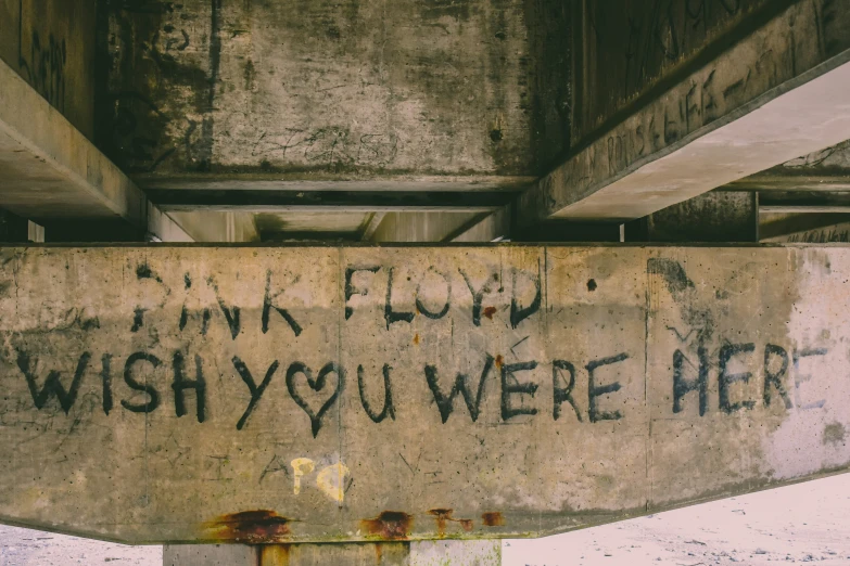 a road sign with writing on it stating drink flood and wish you were here