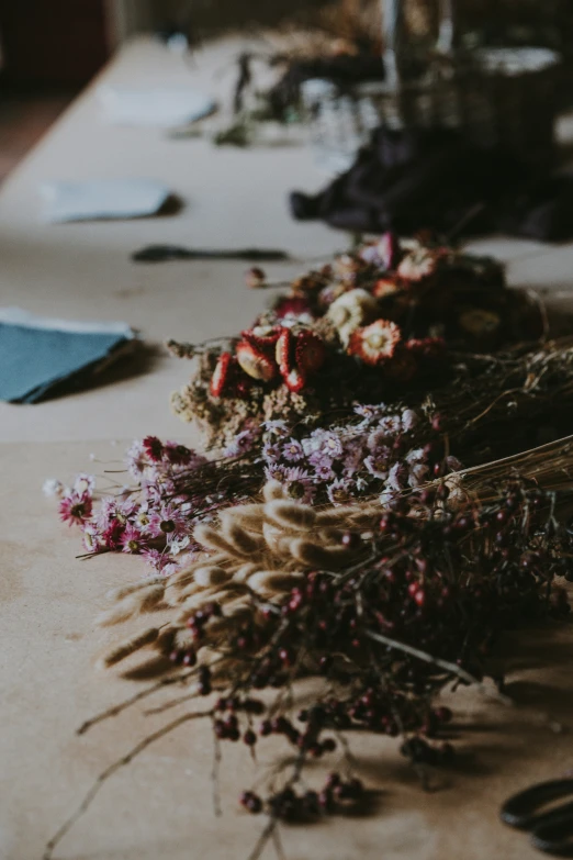 dried flowers on a table with scissors in the background