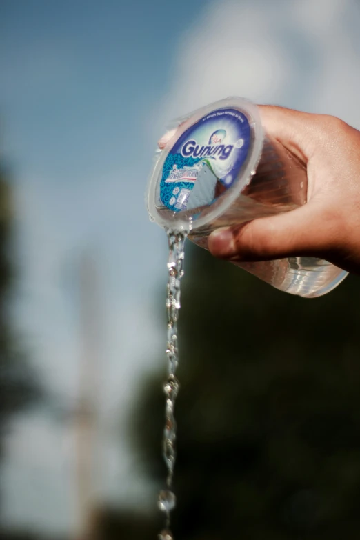 the person is holding a bottle that contains liquid