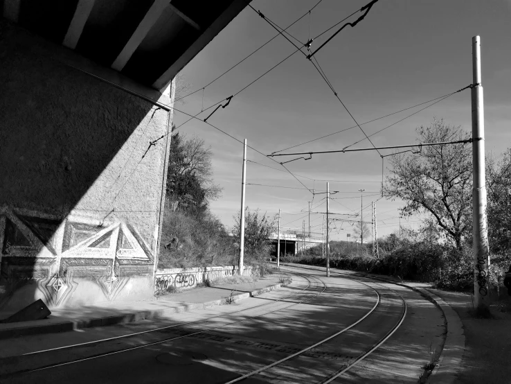 a train track sitting under a bridge next to trees