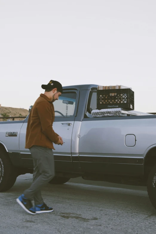 a man walking past a silver truck on the street