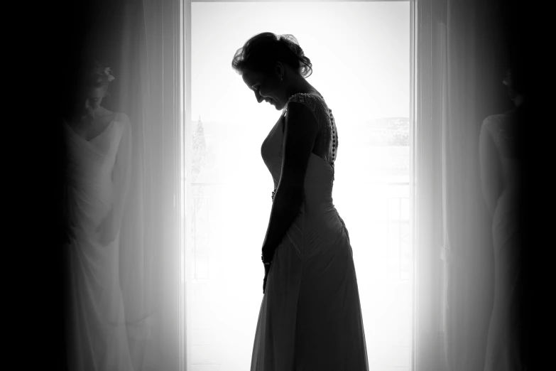 a woman standing by a window looking into the room