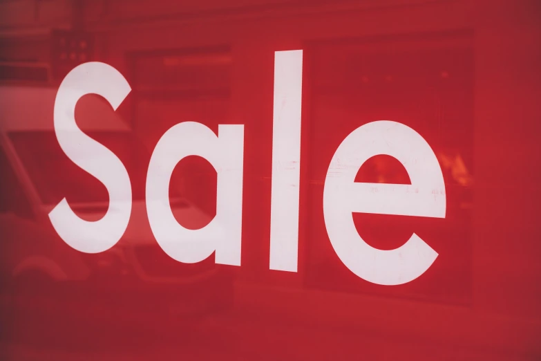 a red sale sign is featured in a window