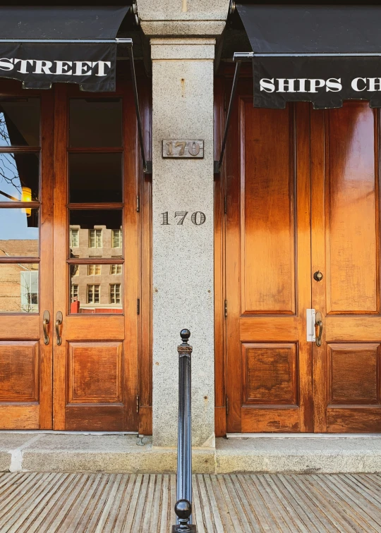 the front entrance of a commercial building with two wood doors