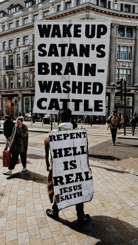 a man is standing on a street holding a sign