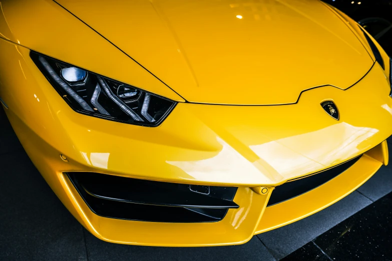 close up s of the front grill of a yellow sports car