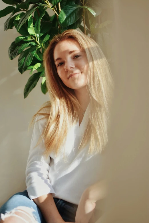 the young lady poses near a potted plant