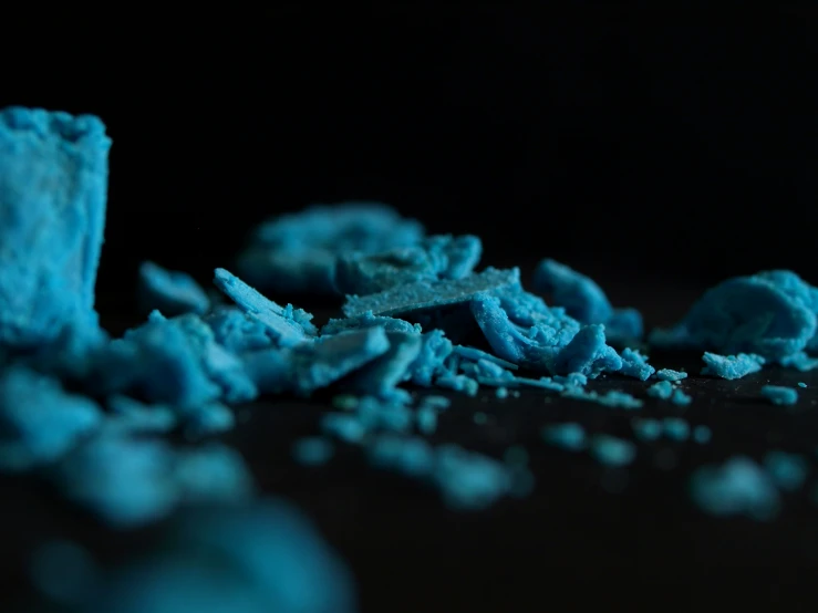 blue sugars sit on a black surface