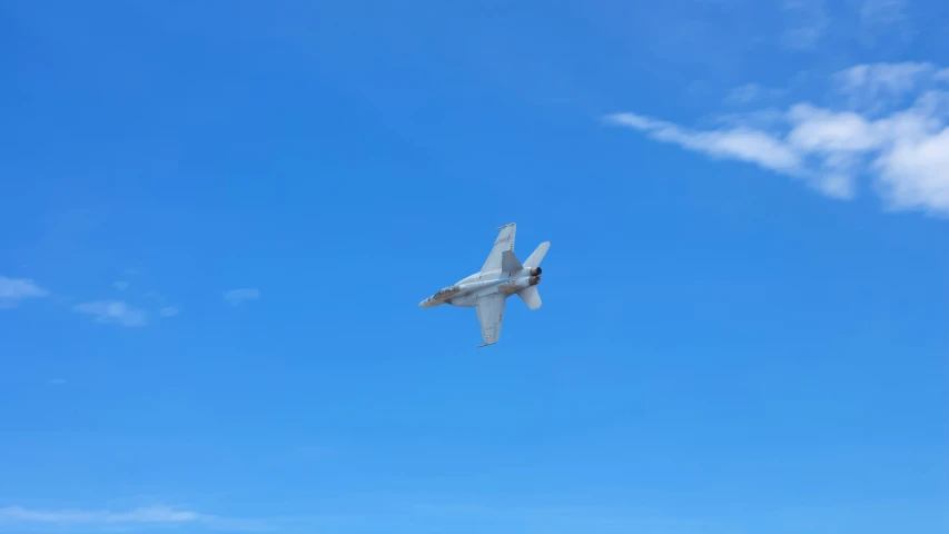 a fighter jet is flying overhead in a clear blue sky