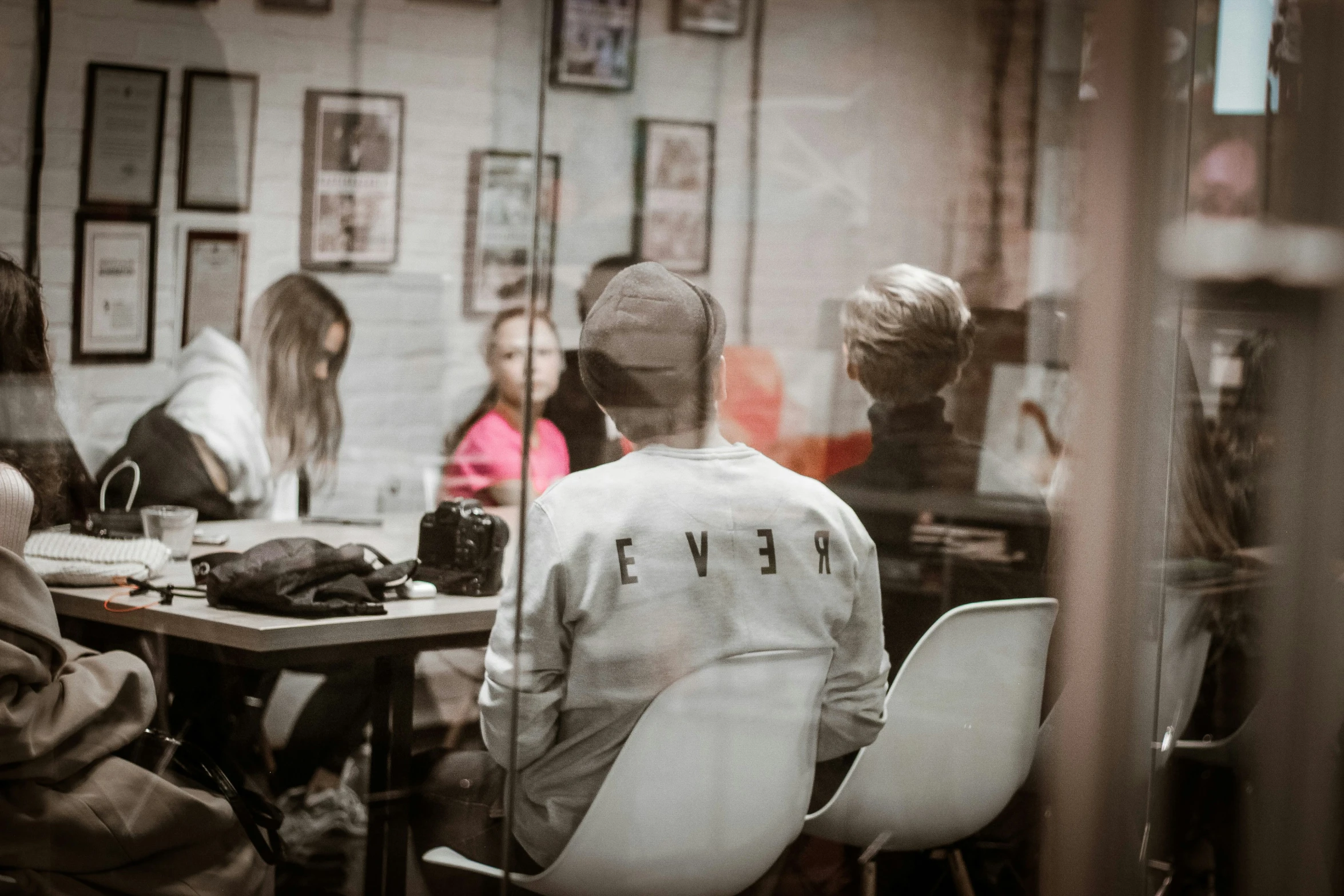 four people are seated at a table in a cafe