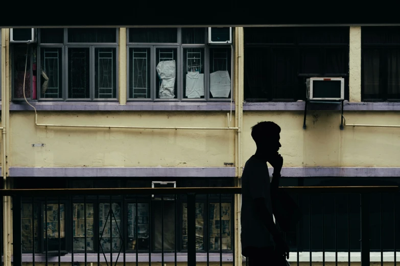 the silhouette of a person standing on a street corner with a window