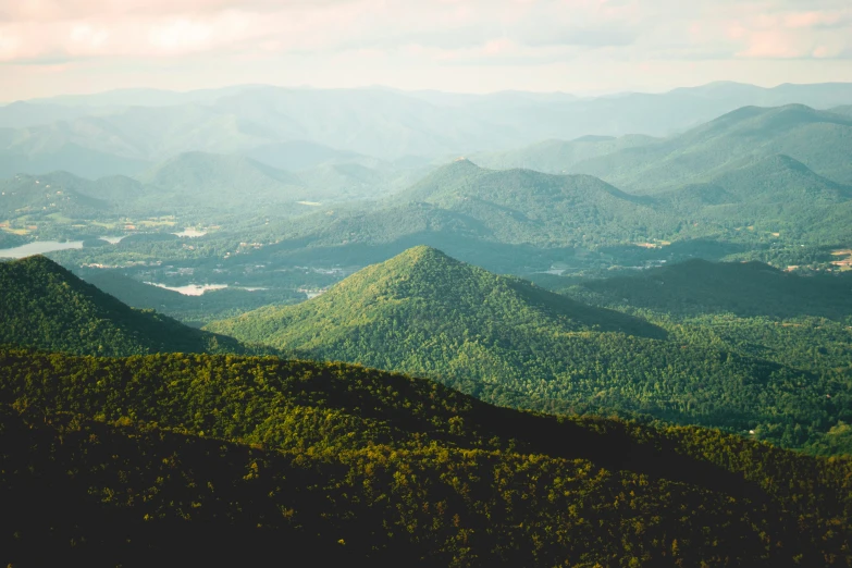 the top of some green mountains with hills