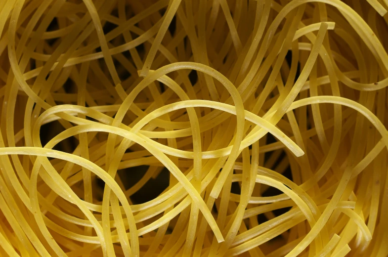a close up of yellow pasta spirals that are sitting on a table