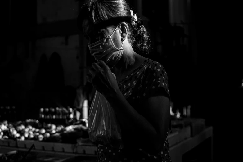 a woman holding a purse standing next to a counter