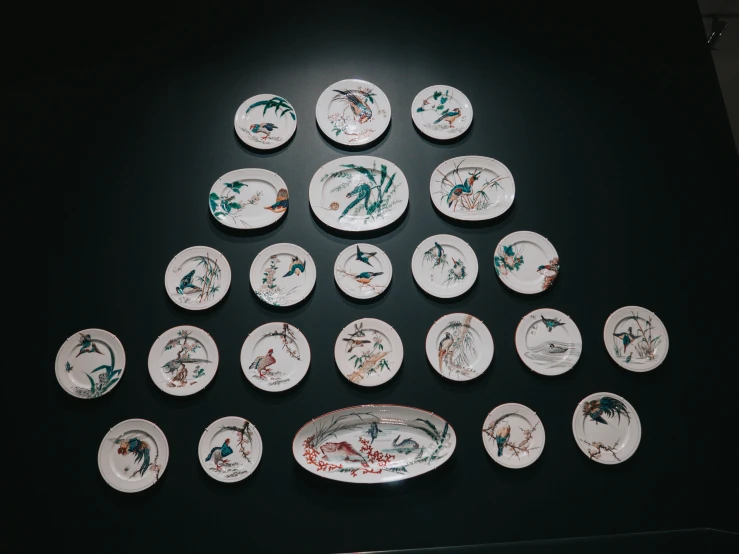 a table topped with white and green plates and decorations