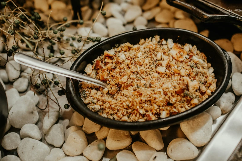 a bowl filled with food sitting on top of rocks