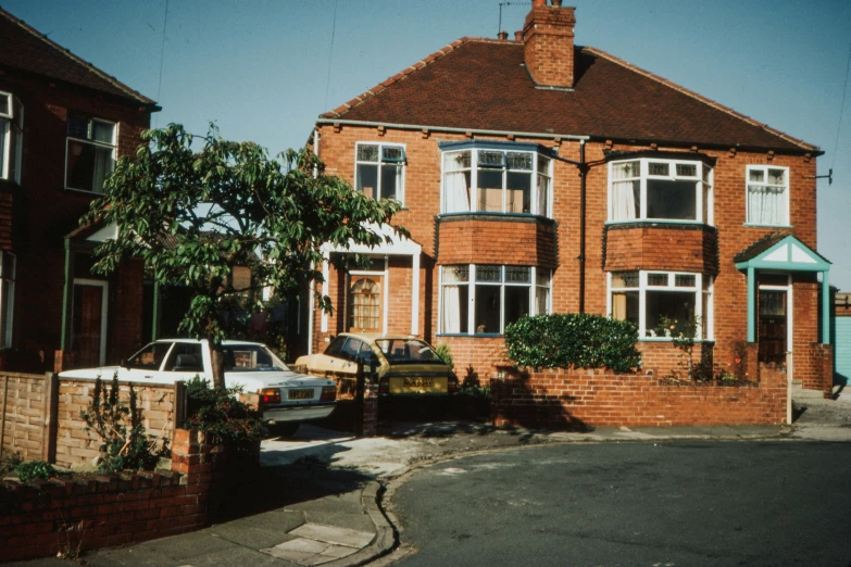 an apartment complex with a large red brick building on the corner and a white truck in front of it