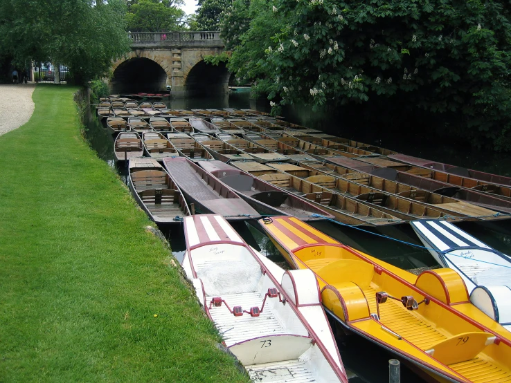 a river filled with boats sitting next to green grass