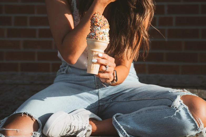 the woman is holding a cone of ice cream