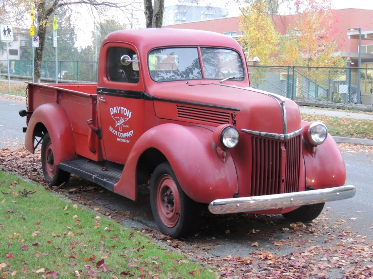 old red truck is parked along the curb