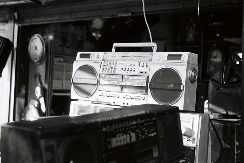 two radio and cassette players sit in front of some wall - mounted speakers