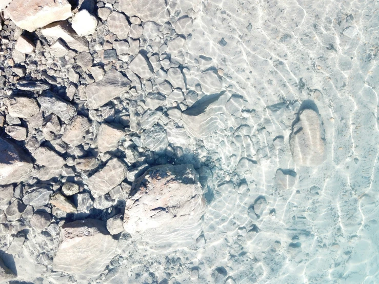 a body of water sitting next to rocks and a sky