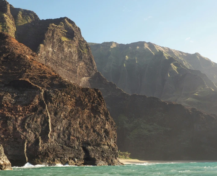 a beautiful scene with mountains and ocean in the background