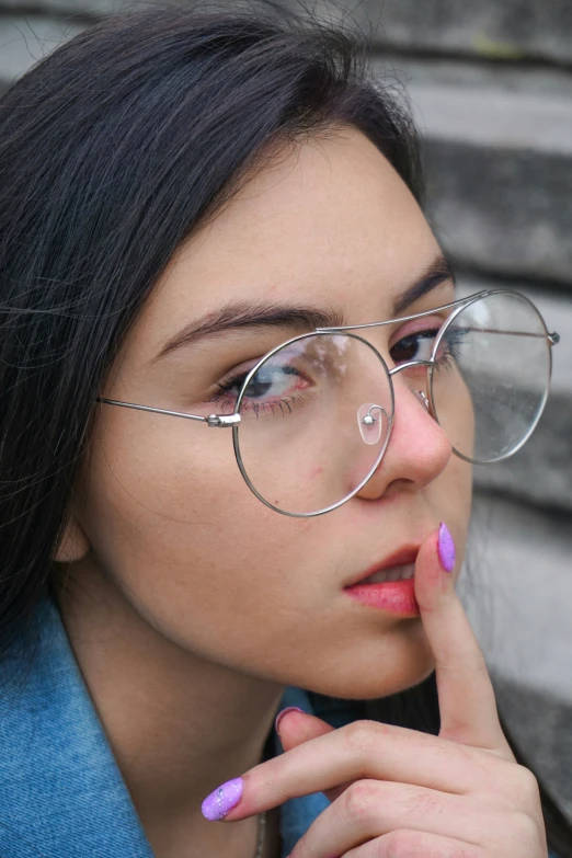 a girl wearing glasses and a blue top