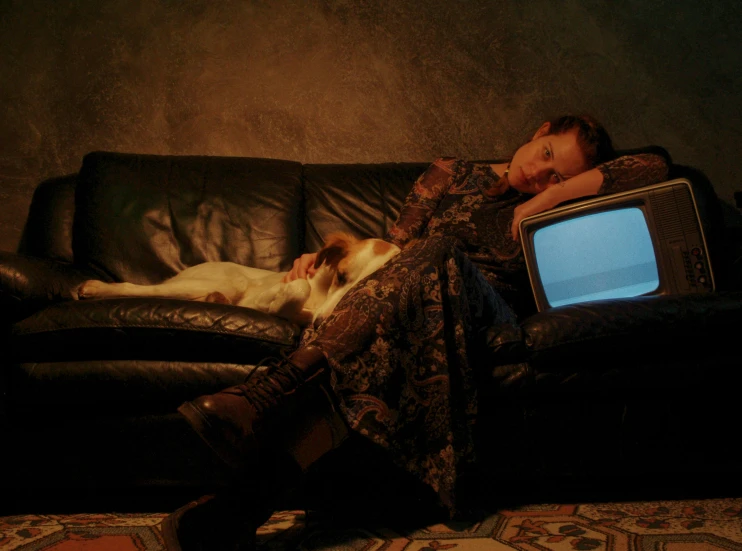 a person sleeps on a leather couch in front of a television