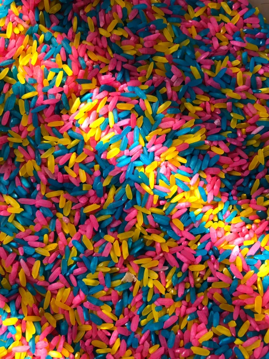 several sprinkles all over a surface with blue, pink, and yellow sprinkles