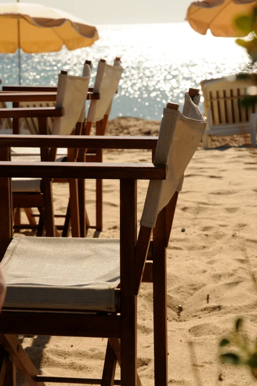 a beach with tables and chairs on the sand