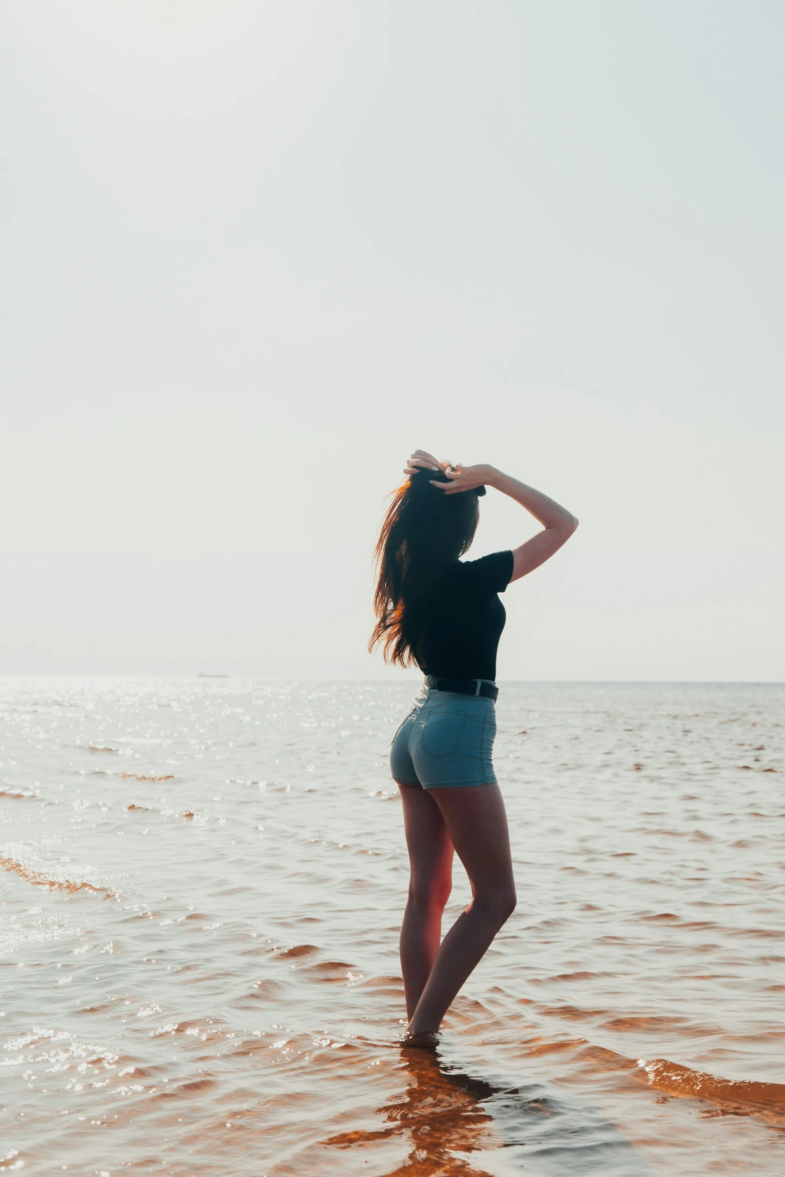 woman standing in the water looking into the distance