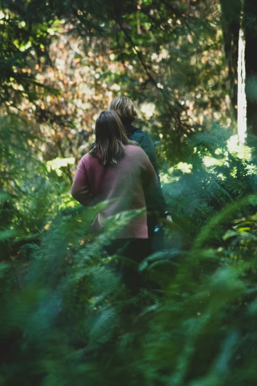 a young woman standing in the woods using her phone