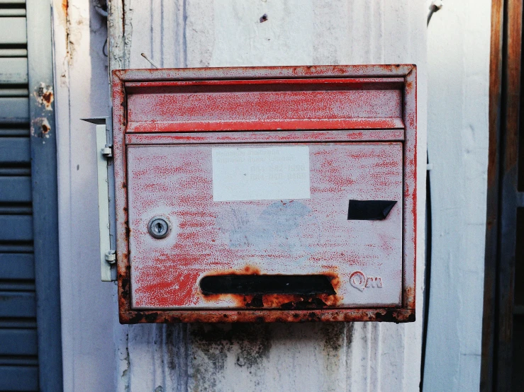 a metal box attached to an old white building