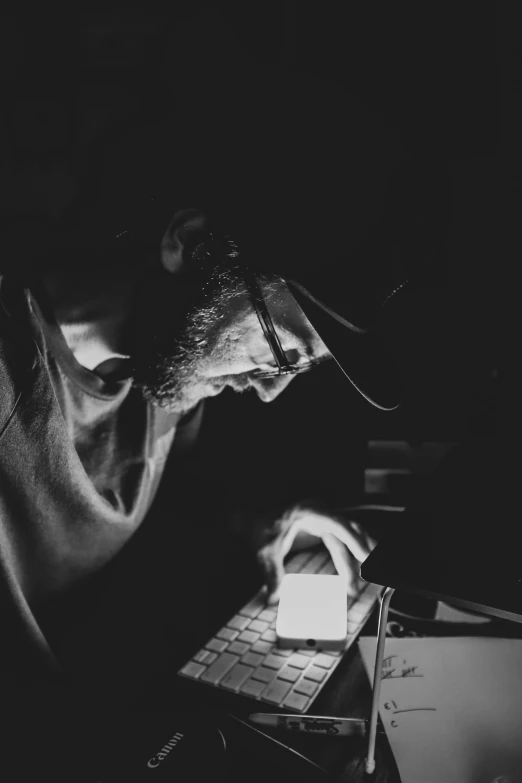 black and white pograph of a man looking at his laptop computer