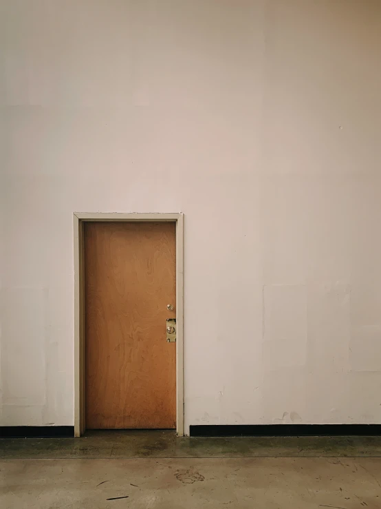 a door open in the corner of a room with concrete floors