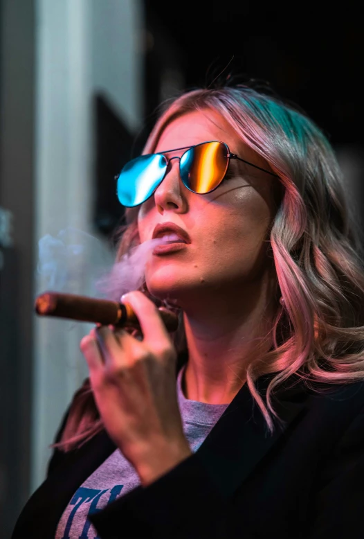 a woman wearing sunglasses smokes a cigarette