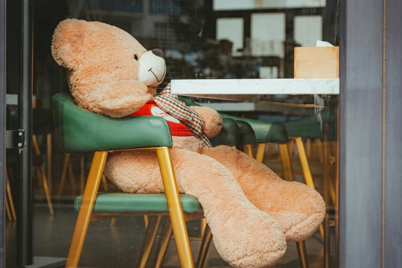 a stuffed bear sitting in a chair outside
