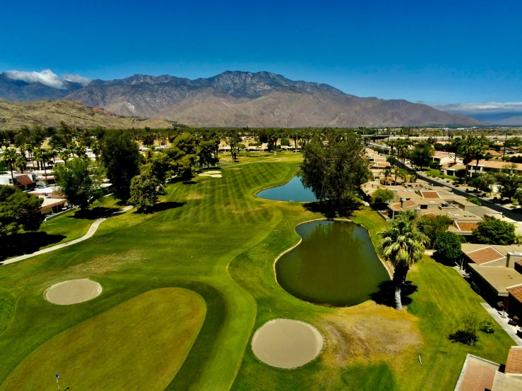 a beautiful golf course with mountains in the background