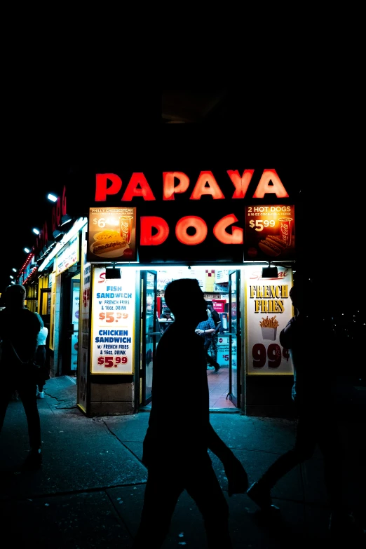 a person walking on the street in front of a restaurant