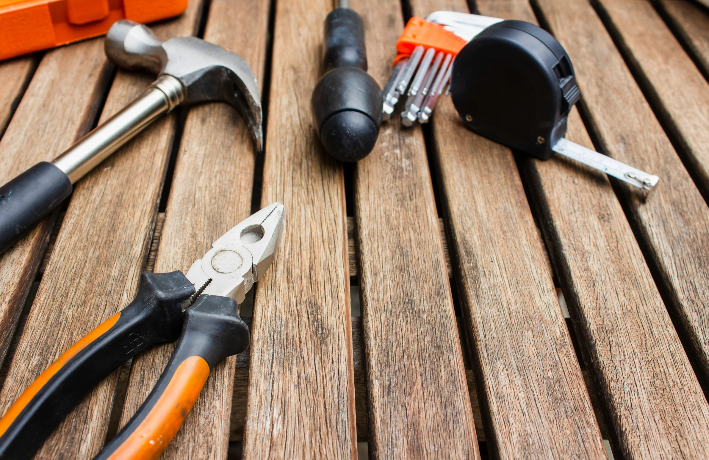 pliers, and other tools sitting on a wooden table