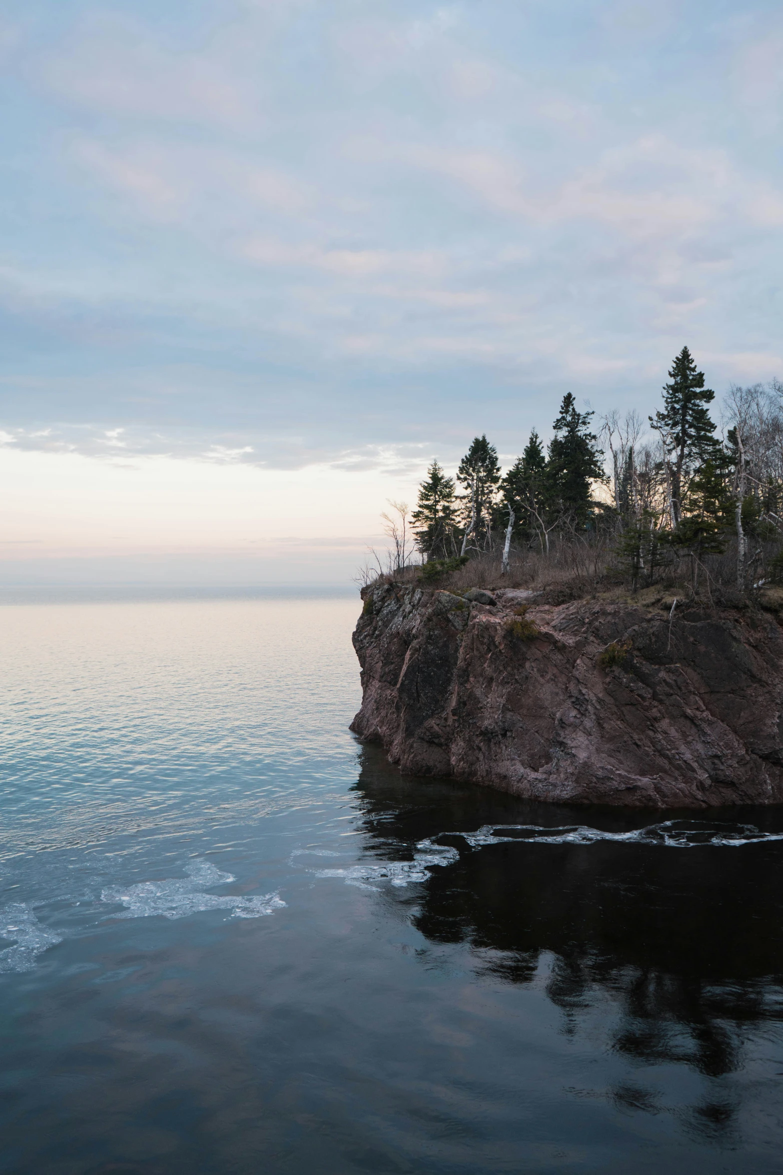 a rocky island with trees on it's edge