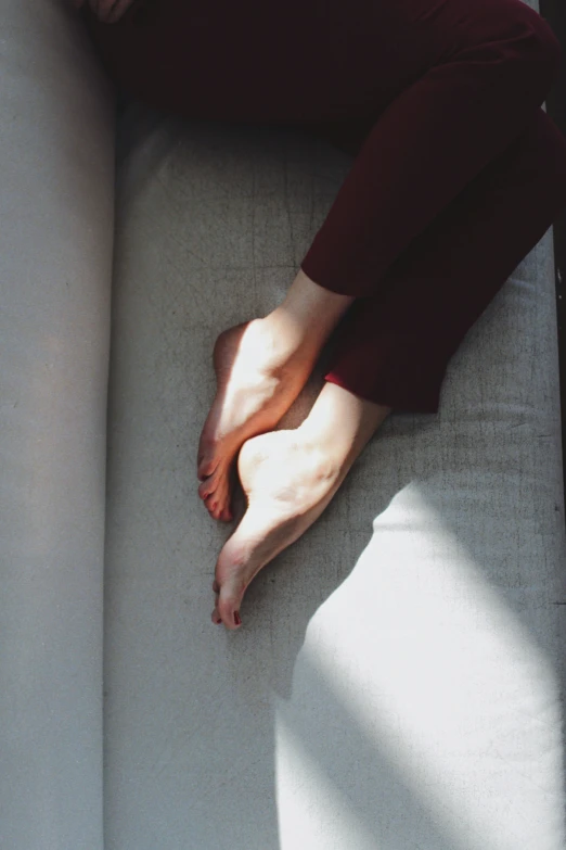 a person is laying on a couch with their bare foot