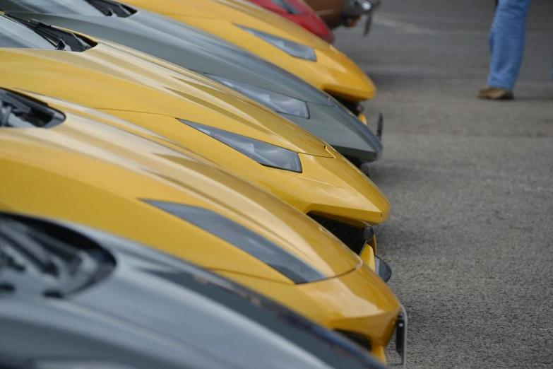 yellow cars are lined up in rows on the ground